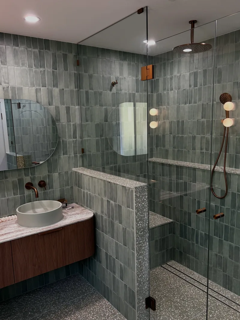 Frameless glass shower screen with brass fittings in a Bateau Bay bathroom